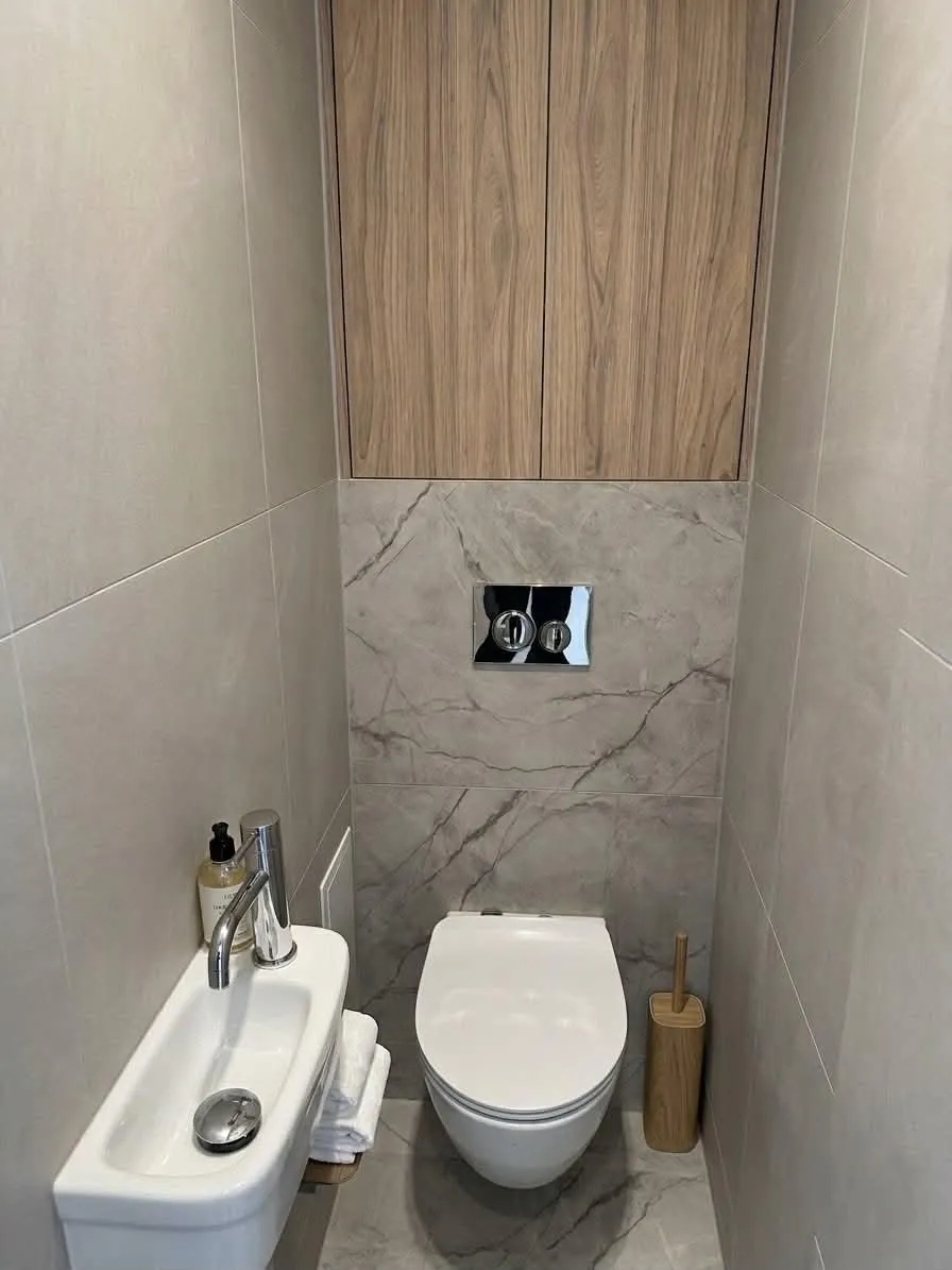 Toaleta z podwieszanym WC, zabudową i płytkami wielkoformatowymi — remont Wrocław Psie Pole